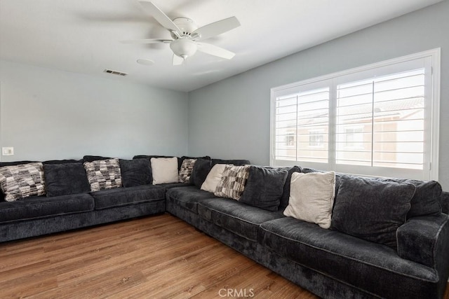 living room with a ceiling fan, wood finished floors, and visible vents