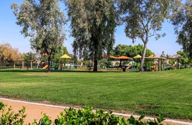 view of property's community with playground community and a yard