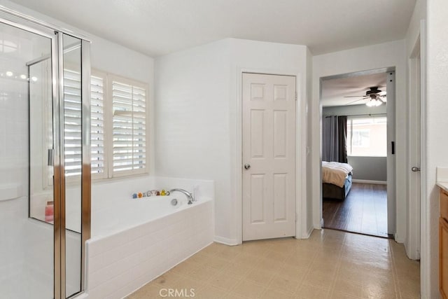 bathroom featuring tile patterned floors, ceiling fan, a stall shower, a bath, and vanity