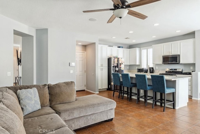 living room featuring light tile patterned floors, baseboards, ceiling fan, and recessed lighting