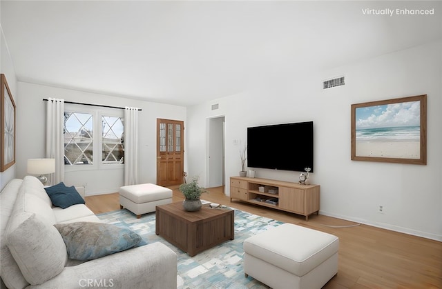 living area featuring light wood-style flooring, baseboards, and visible vents