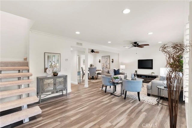 living room with crown molding, stairway, recessed lighting, and light wood-type flooring