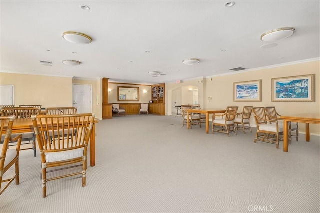 dining space with visible vents, light colored carpet, and crown molding