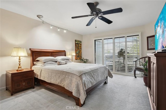 bedroom featuring access to exterior, light colored carpet, and a ceiling fan