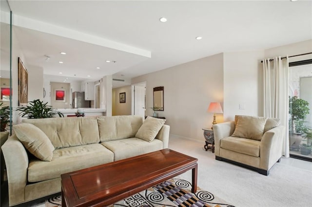 living room with recessed lighting, baseboards, and light carpet