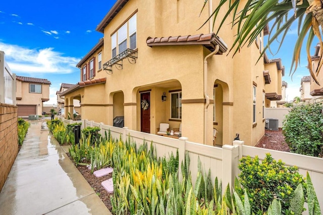 view of home's exterior with a fenced front yard, stucco siding, and a tile roof