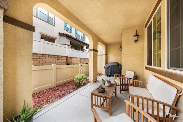 view of patio / terrace with grilling area, an outdoor hangout area, and fence