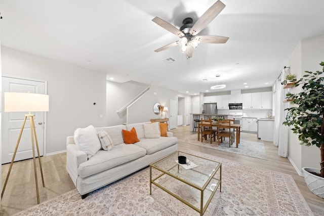 living area with a ceiling fan, baseboards, visible vents, recessed lighting, and light wood-type flooring