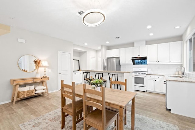 dining area featuring recessed lighting, visible vents, light wood-style flooring, and baseboards