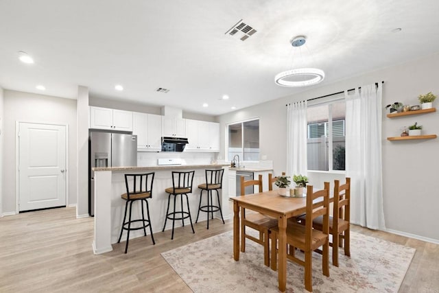 dining room featuring visible vents, recessed lighting, light wood-style floors, and baseboards