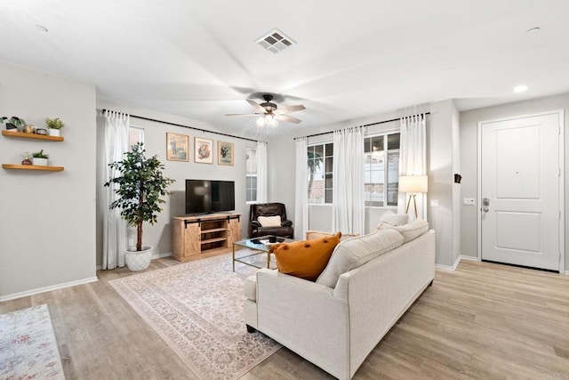 living area featuring visible vents, a ceiling fan, recessed lighting, light wood finished floors, and baseboards