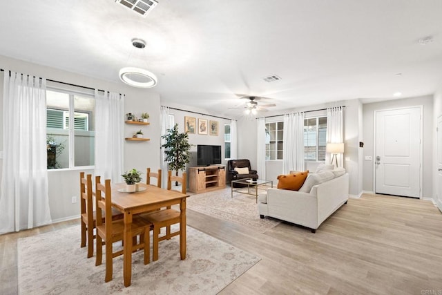 dining space with visible vents, a healthy amount of sunlight, and light wood-type flooring