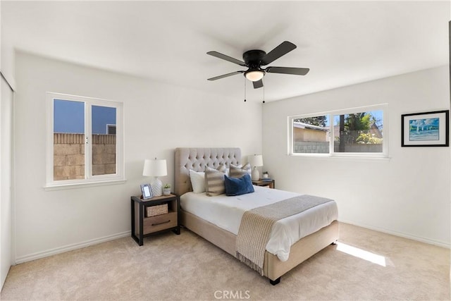 bedroom with light carpet, baseboards, and ceiling fan