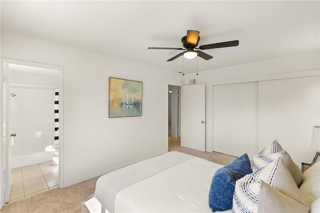 bedroom featuring ceiling fan, connected bathroom, a closet, light colored carpet, and baseboards