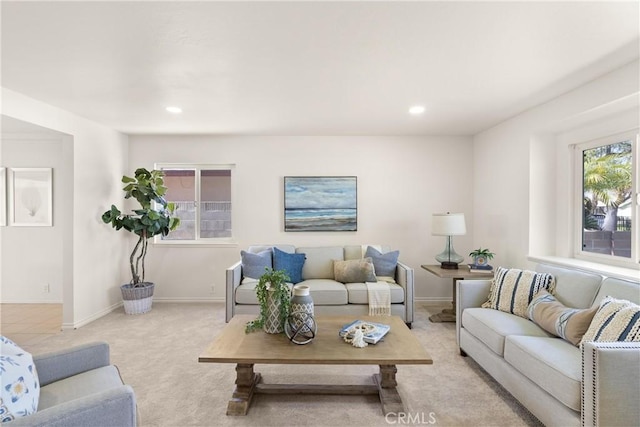 living room with recessed lighting, light colored carpet, and baseboards