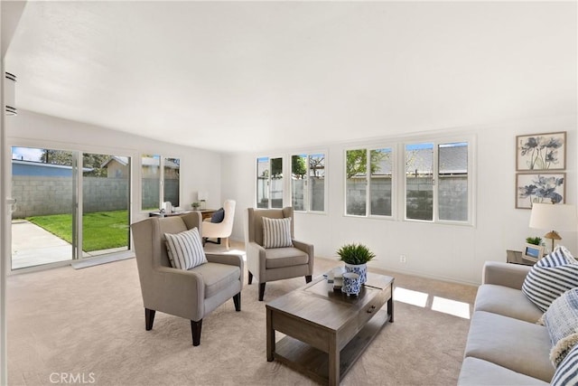 living area with plenty of natural light and light colored carpet