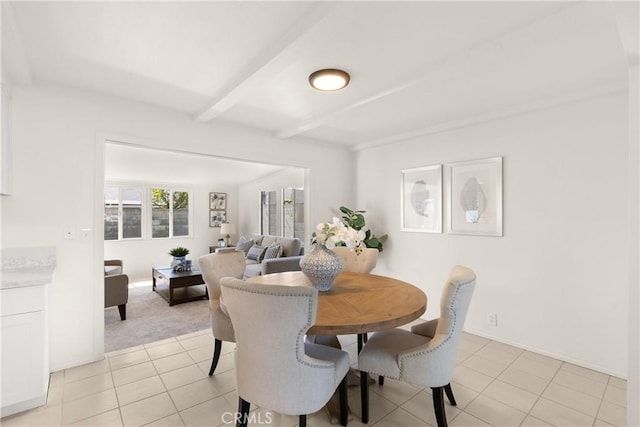 dining area with light tile patterned floors, baseboards, and beam ceiling