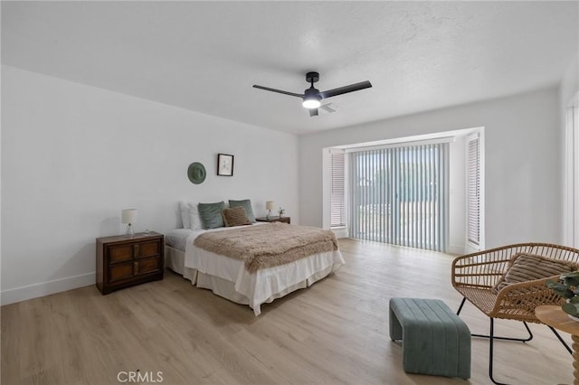 bedroom featuring light wood-type flooring, baseboards, visible vents, and a ceiling fan