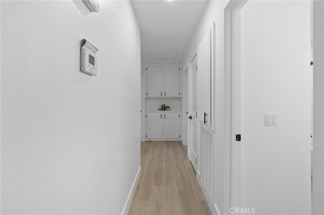 hall featuring baseboards and light wood finished floors