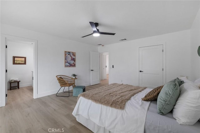 bedroom with ceiling fan, visible vents, baseboards, and light wood-style flooring