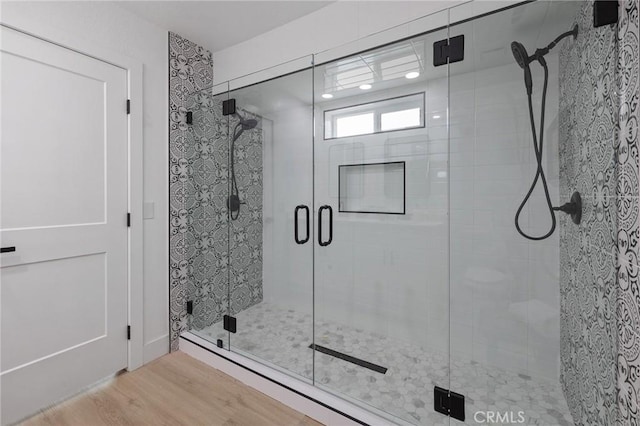 bathroom with a shower stall and wood finished floors