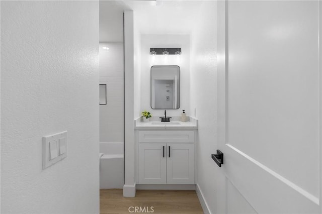 full bath with vanity, wood finished floors, and tub / shower combination