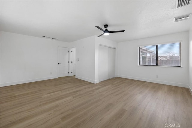 unfurnished room featuring light wood-style floors, visible vents, and baseboards