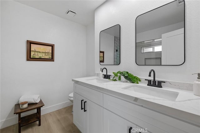 full bathroom featuring a sink, visible vents, toilet, and wood finished floors