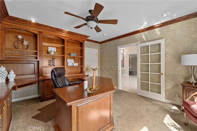 home office featuring light colored carpet, baseboards, ceiling fan, and ornamental molding