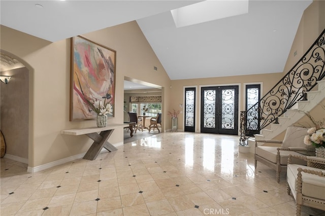 foyer with high vaulted ceiling, stairway, arched walkways, french doors, and baseboards