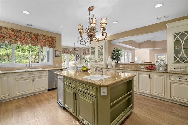 kitchen with visible vents, a sink, light wood-style floors, green cabinetry, and a chandelier