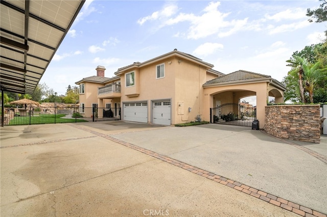 view of property exterior featuring stucco siding, a gate, fence, concrete driveway, and an attached garage