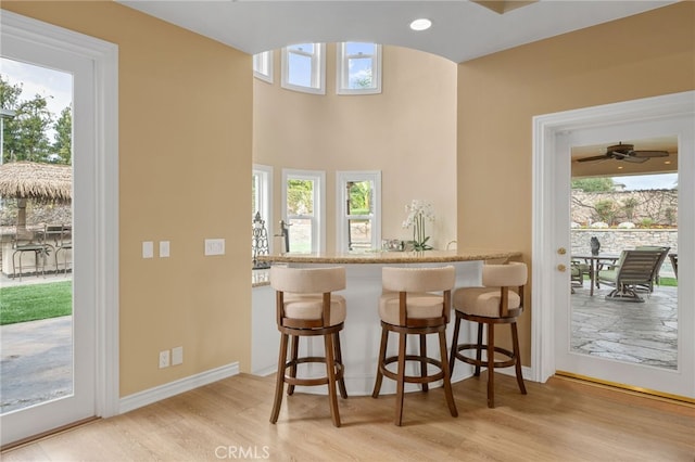 bar with recessed lighting, plenty of natural light, wood finished floors, and baseboards