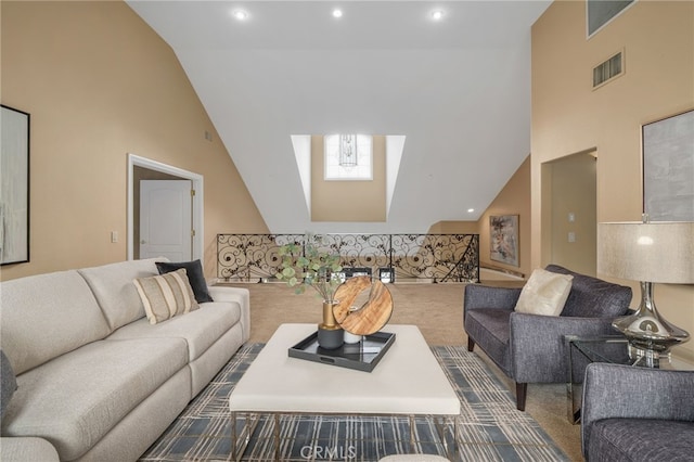 carpeted living room featuring a skylight, recessed lighting, visible vents, and high vaulted ceiling