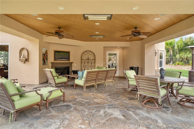 view of patio featuring an outdoor living space with a fireplace, outdoor dining area, and ceiling fan