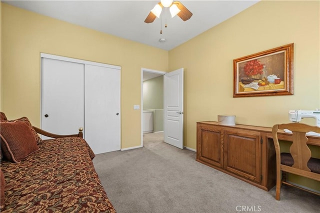 bedroom featuring light carpet, ceiling fan, baseboards, and a closet