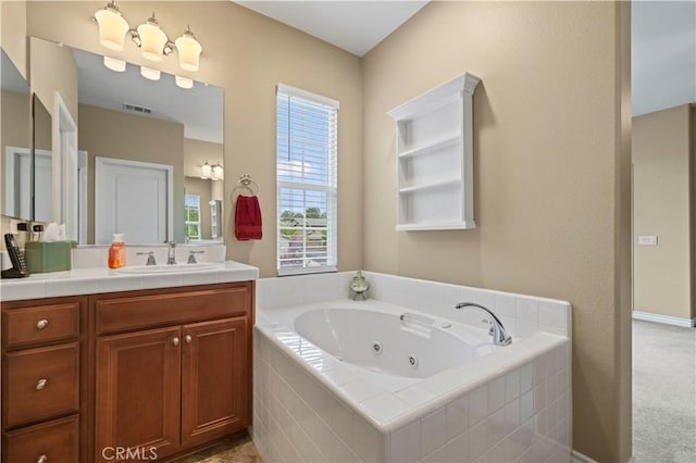 bathroom with visible vents, vanity, and a whirlpool tub