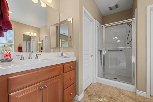 bathroom with vanity, baseboards, visible vents, and a stall shower