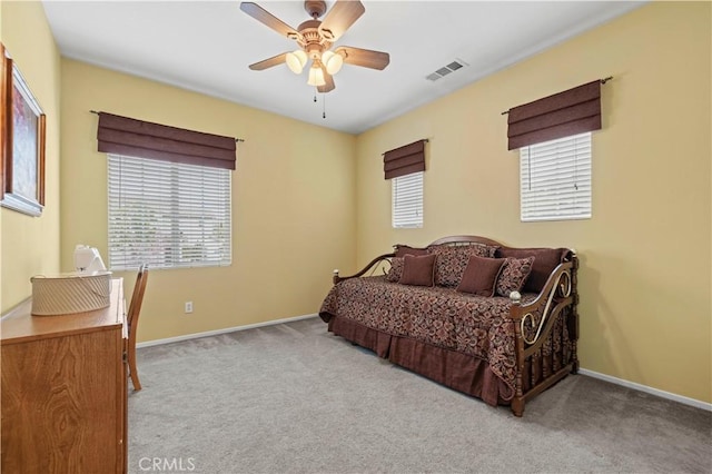 carpeted bedroom with visible vents, baseboards, and a ceiling fan