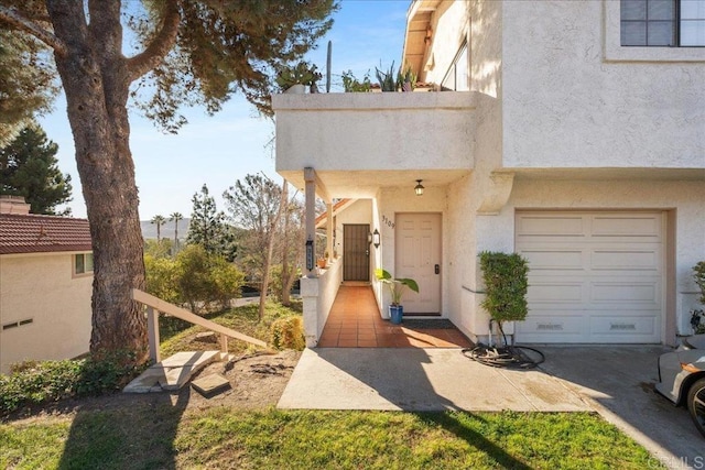 property entrance featuring a garage and stucco siding