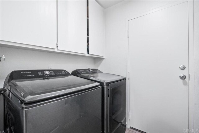 washroom with cabinet space and washing machine and clothes dryer