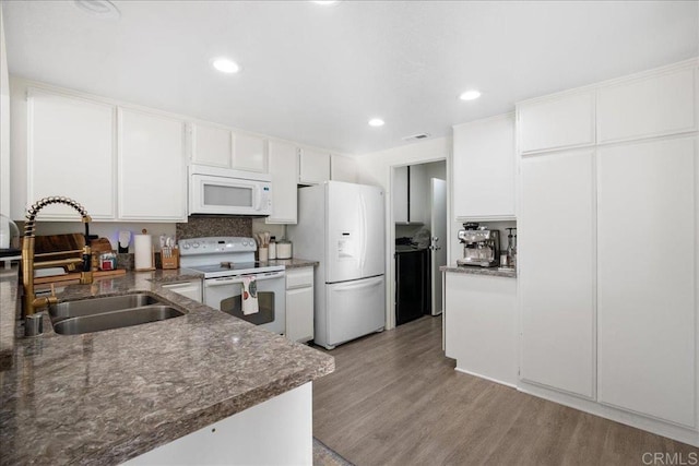 kitchen featuring white appliances, visible vents, light wood-style flooring, a sink, and white cabinetry