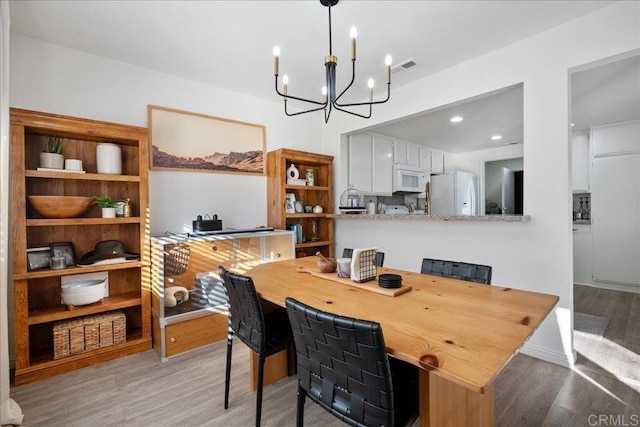 office featuring recessed lighting, visible vents, an inviting chandelier, and wood finished floors