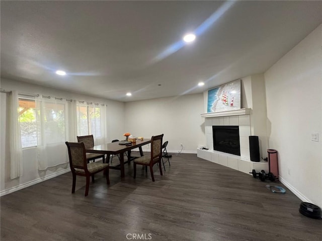 dining area featuring recessed lighting, baseboards, dark wood-style floors, and a tiled fireplace