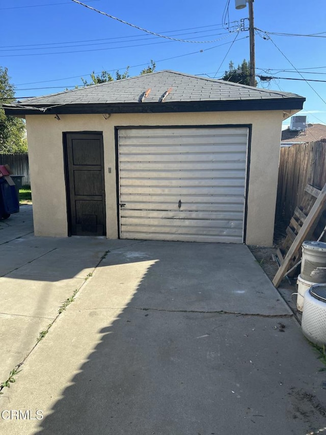 garage featuring fence and driveway