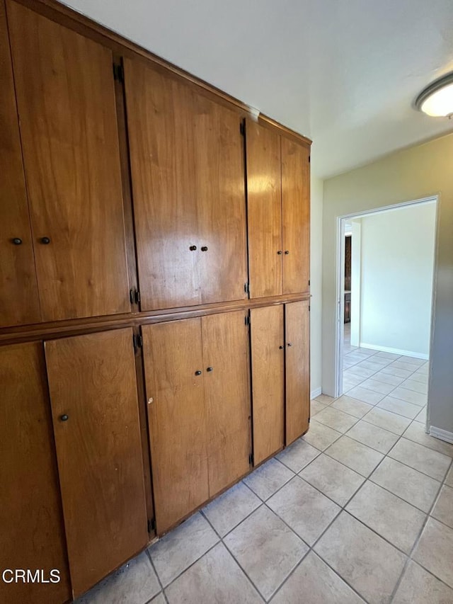 hallway featuring light tile patterned flooring and baseboards