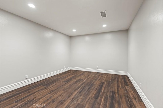 empty room with visible vents, recessed lighting, dark wood-style floors, and baseboards