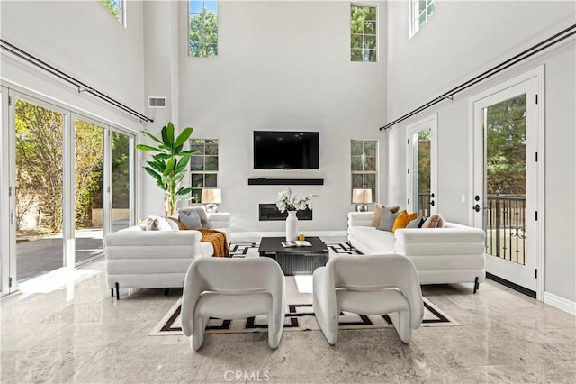 dining space with visible vents, marble finish floor, french doors, baseboards, and a towering ceiling