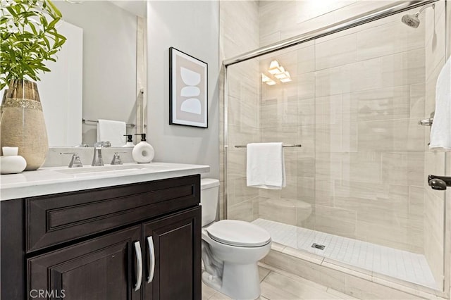 full bath featuring a stall shower, toilet, and vanity