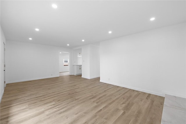 unfurnished living room featuring recessed lighting, light wood-style floors, and baseboards